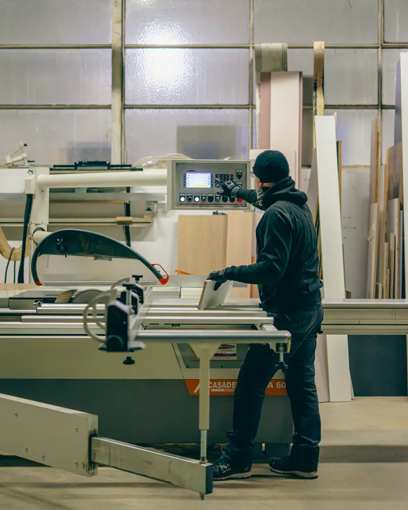 Artisan de Vivet Agencement utilisant une scie à panneaux numérique dans l'atelier de fabrication à La Ravoire.