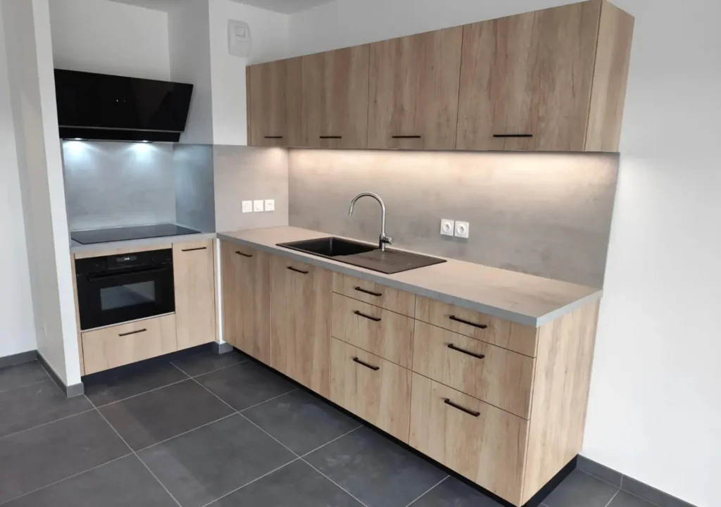 Cuisine sur mesure en bois réalisée par Vivet Agencement avec plan de travail effet béton et éclairage LED intégré.