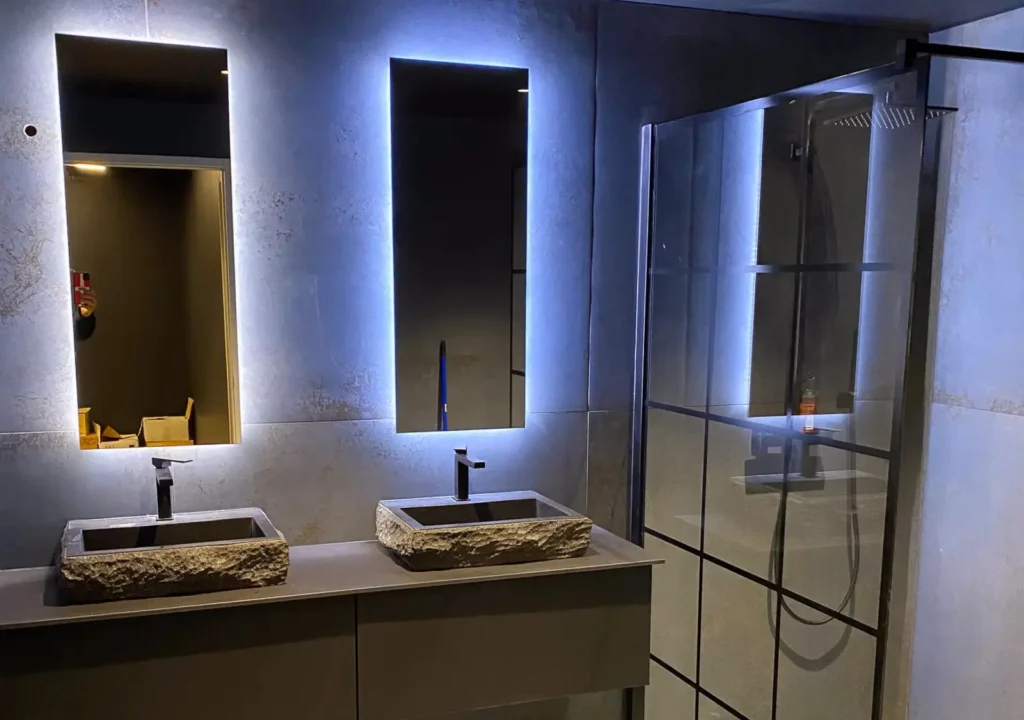 Salle de bain sur mesure réalisée par Vivet Agencement avec double vasque, miroirs rétroéclairés et douche à l'italienne.
