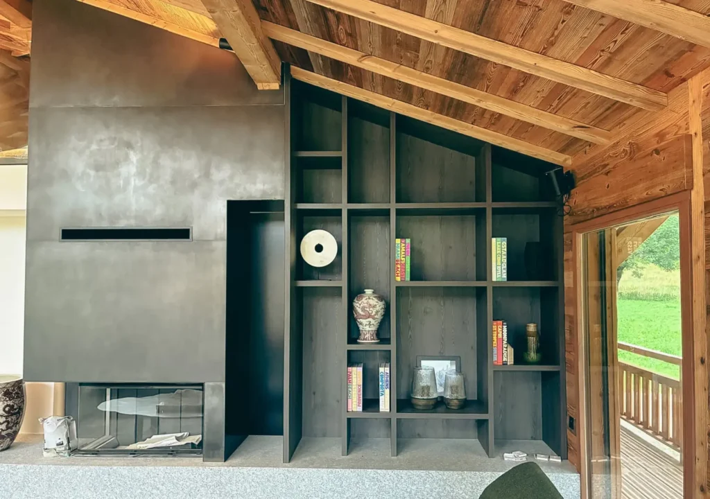 Bibliothèque sur mesure avec cheminée réalisée par Vivet Agencement dans un chalet en Savoie.