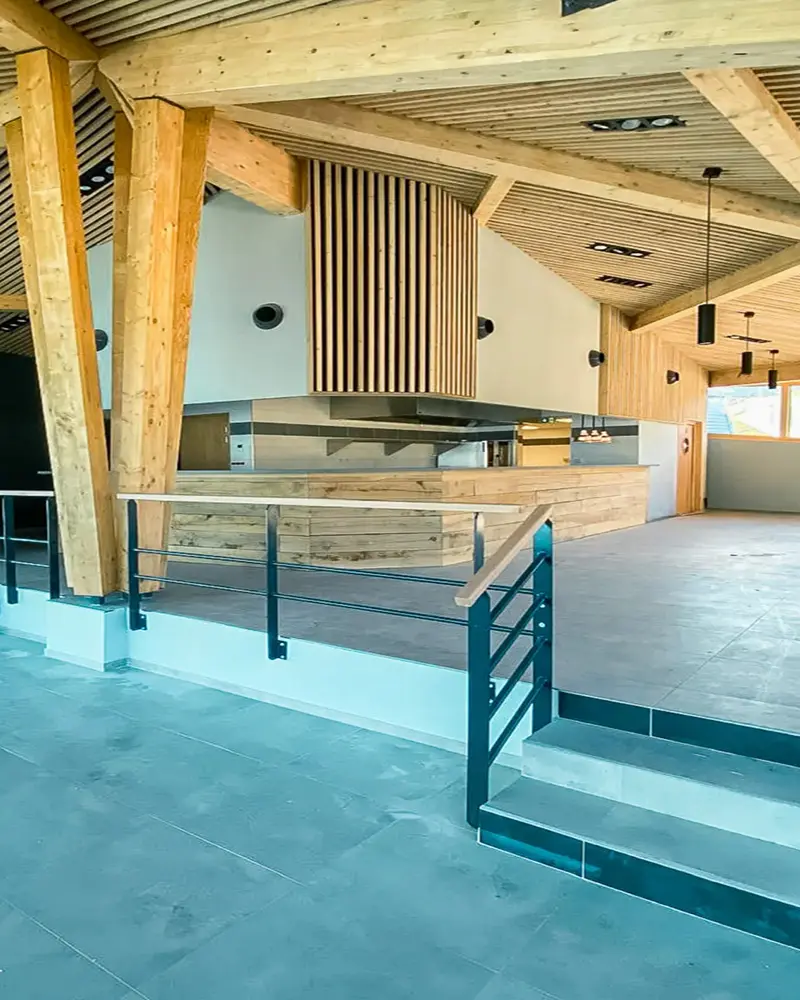 Bar et espace de restauration sur mesure réalisés par Vivet Agencement avec comptoir en bois et habillages muraux.