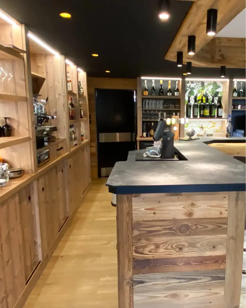 Bar de restaurant sur mesure en bois réalisé par Vivet Agencement avec comptoir et rangements intégrés.