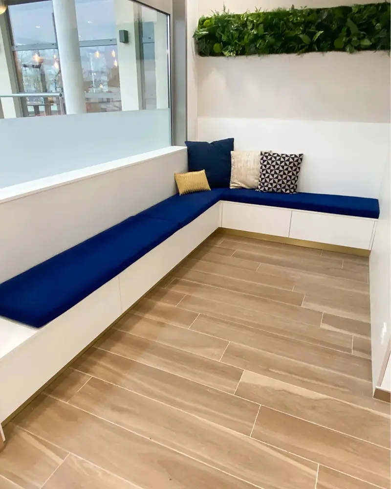Banquette d'accueil sur mesure réalisée par Vivet Agencement pour la salle d'attente d'un cabinet d'ophtalmologie.