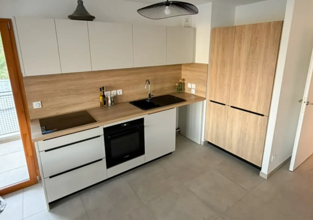 Cuisine sur mesure en bois et blanc réalisée par Vivet Agencement avec meubles intégrés et rangements optimisés.