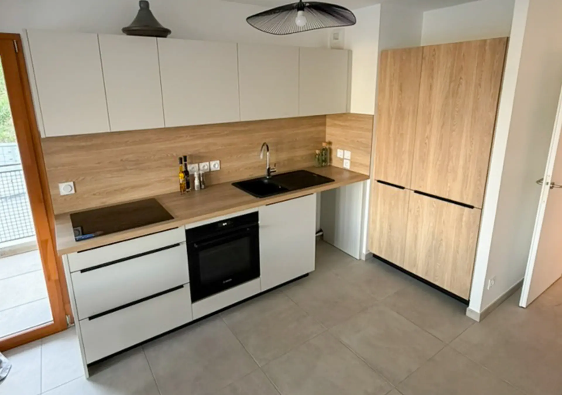 Cuisine sur mesure en bois et blanc réalisée par Vivet Agencement avec meubles intégrés et rangements optimisés.