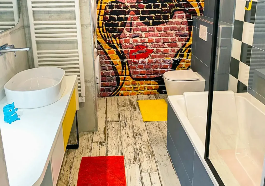 Salle de bain sur mesure réalisée par Vivet Agencement avec meuble vasque, baignoire et décoration murale personnalisée.