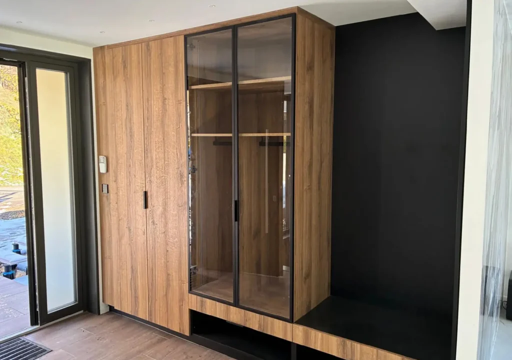 Dressing d'entrée sur mesure avec vitrine en verre fumé réalisé par Vivet Agencement.