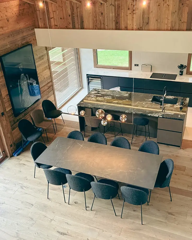 Cuisine sur mesure avec îlot central en pierre réalisée par Vivet Agencement dans un chalet en Savoie.